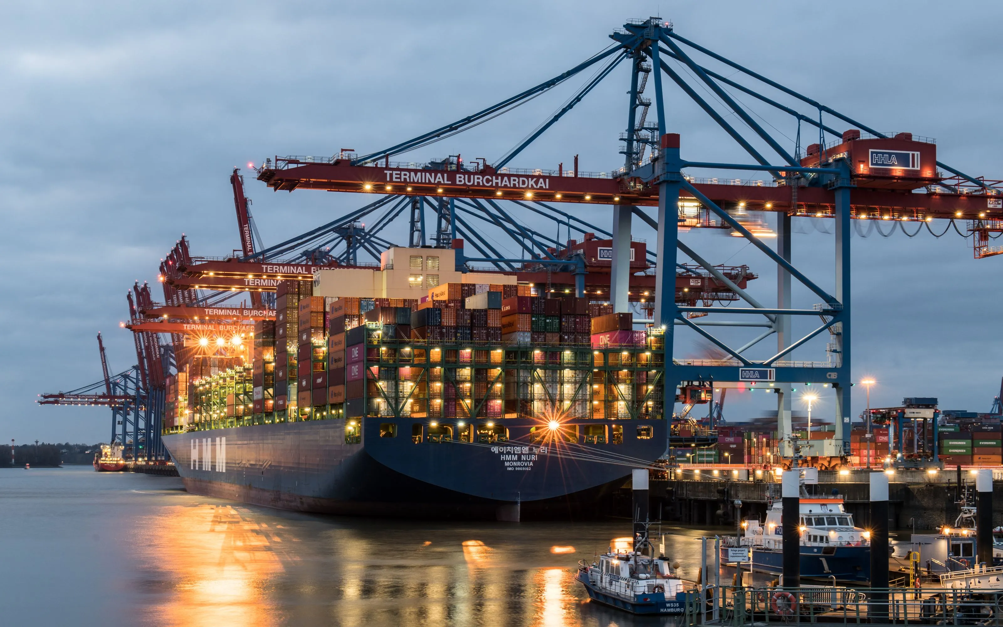 A container ship berthed at a terminal at dusk