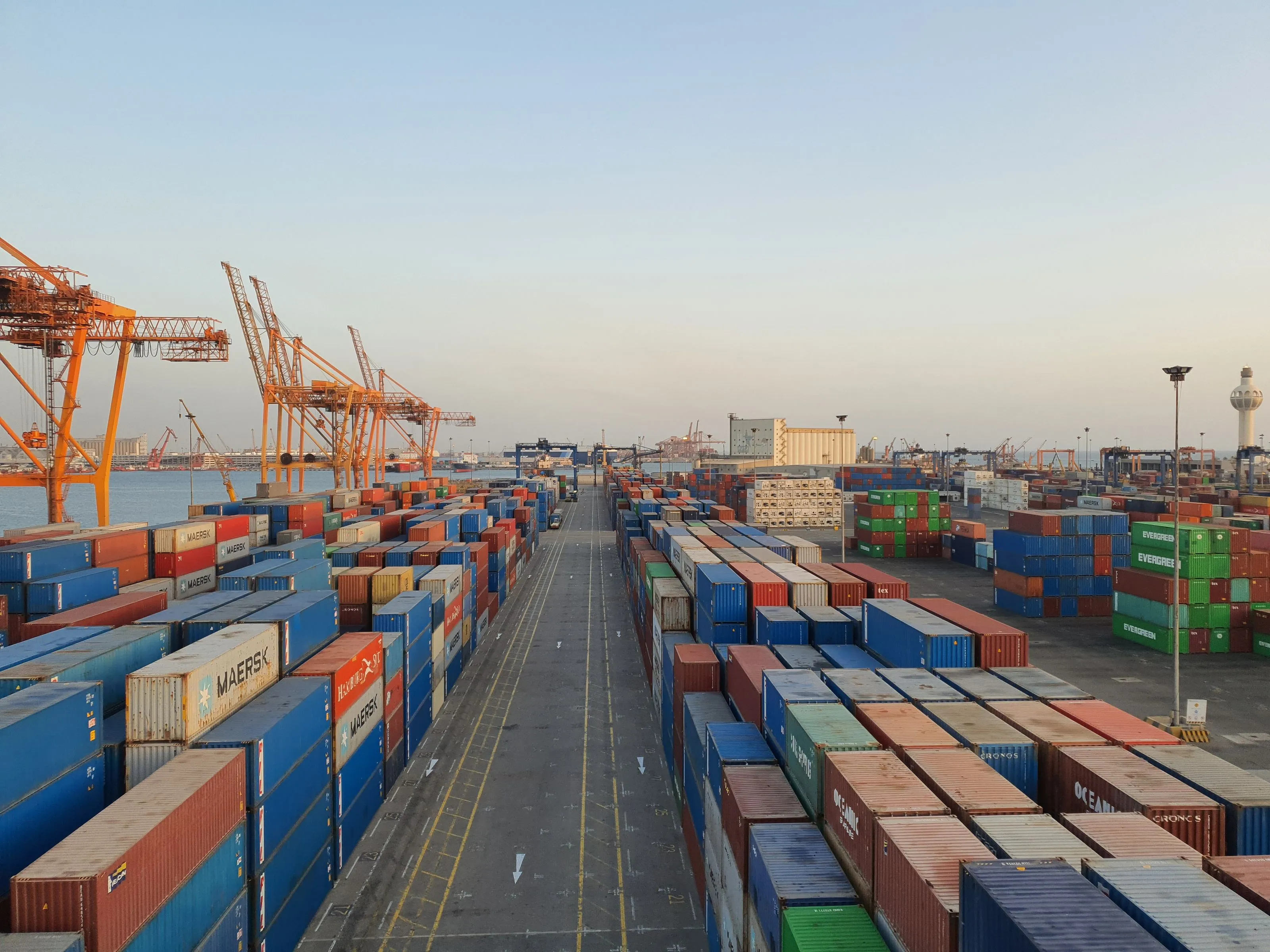 Containers and gantry cranes at a port terminal at sunset
